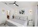 Serene main bedroom boasts a stylish bed, elegant lighting, ceiling fan, and doorway to an ensuite bathroom at 18530 Dobson Dr, Hudson, FL 34667
