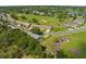 Aerial view of townhomes surrounded by golf course featuring mature trees and green grass at 18736 Bent Pine Dr, Hudson, FL 34667