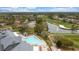 Aerial view of a community pool and hot tub area, plus a golf course with a lake and fountain at 18736 Bent Pine Dr, Hudson, FL 34667