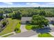 Aerial view of single-story home featuring mature trees, manicured lawn, and extended driveway at 18736 Bent Pine Dr, Hudson, FL 34667