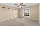 Well-lit bedroom features neutral walls, carpet, and a ceiling fan at 18736 Bent Pine Dr, Hudson, FL 34667