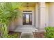 Welcoming front porch featuring a glass front door with decorative sidelights and manicured landscaping at 18736 Bent Pine Dr, Hudson, FL 34667