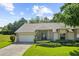 Charming single-story home with lush landscaping, a well-manicured lawn, and inviting curb appeal at 18736 Bent Pine Dr, Hudson, FL 34667