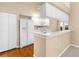 Well-lit kitchen featuring white appliances and cabinetry, and breakfast bar at 18736 Bent Pine Dr, Hudson, FL 34667