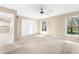 Bright living room with double doors to backyard, ceiling fan, and natural light at 18736 Bent Pine Dr, Hudson, FL 34667