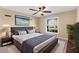 Comfortable main bedroom with ceiling fan, plush bed, and picture window at 18736 Bent Pine Dr, Hudson, FL 34667