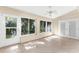 Sunroom boasts neutral tile floors, a ceiling fan, and an abundance of windows, creating a bright, airy space at 18736 Bent Pine Dr, Hudson, FL 34667