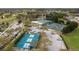 Aerial view of tennis and pickleball courts with lush landscaping and golf course in a vibrant community at 18736 Bent Pine Dr, Hudson, FL 34667