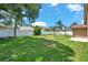 Spacious fenced backyard with green grass, mature trees, and potential for various outdoor activities and gardening at 2048 Ground Squirrel Dr, New Port Richey, FL 34655