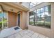 Close-up of the front entry area featuring brick accents, tile flooring, and a large window at 2048 Ground Squirrel Dr, New Port Richey, FL 34655