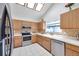 Charming kitchen featuring wood cabinetry, stainless steel appliances, and bright natural lighting at 2048 Ground Squirrel Dr, New Port Richey, FL 34655