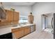 Kitchen boasting wood cabinetry, stainless steel appliances, tile floors and access to back yard at 2048 Ground Squirrel Dr, New Port Richey, FL 34655