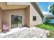 Inviting patio with brick pavers and sliding glass doors to the home's interior and a chair to sit and enjoy the outdoors at 2048 Ground Squirrel Dr, New Port Richey, FL 34655
