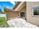 Inviting patio with brick pavers and sliding glass doors to the home's interior and a chair to sit and enjoy the outdoors at 2048 Ground Squirrel Dr, New Port Richey, FL 34655
