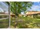 Backyard view shows mature landscaping and a building with light yellow siding at 2101 Sunset Point Rd # 201, Clearwater, FL 33765