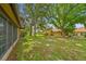 The backyard features mature trees and landscaping around the light-yellow siding of the house at 2101 Sunset Point Rd # 201, Clearwater, FL 33765