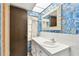 Bathroom featuring blue floral wallpaper, a white countertop, and wood door at 2101 Sunset Point Rd # 201, Clearwater, FL 33765