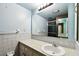 Bathroom with light blue walls, tile countertops, and a large mirror at 2101 Sunset Point Rd # 201, Clearwater, FL 33765