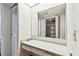 Bathroom vanity area with a long countertop and a large mirror and a door to the walk-in closet at 2101 Sunset Point Rd # 201, Clearwater, FL 33765