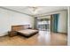 Spacious bedroom with light wood floors and a large glass doors to a screened porch at 2101 Sunset Point Rd # 201, Clearwater, FL 33765