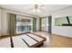 Bright bedroom featuring light wood floors, a ceiling fan, and large windows at 2101 Sunset Point Rd # 201, Clearwater, FL 33765