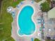 Overhead shot of a community pool with surrounding lounge chairs and a brick-paved patio at 2101 Sunset Point Rd # 201, Clearwater, FL 33765