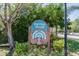 Raintree Village community sign surrounded by lush, green landscaping on a sunny day at 2101 Sunset Point Rd # 201, Clearwater, FL 33765