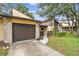 Inviting front exterior featuring a stone facade, garage, and landscaped walkway at 2101 Sunset Point Rd # 201, Clearwater, FL 33765