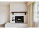 Close up on the white-painted brick fireplace with a wooden mantel at 2101 Sunset Point Rd # 201, Clearwater, FL 33765