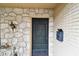 Close-up of the front door featuring stone accents and a vintage mailbox at 2101 Sunset Point Rd # 201, Clearwater, FL 33765