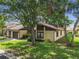Charming home with well-manicured front yard featuring mature trees and lush green lawn at 2101 Sunset Point Rd # 201, Clearwater, FL 33765