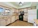 An updated kitchen features light wood cabinets, modern appliances, and a bright window at 2101 Sunset Point Rd # 201, Clearwater, FL 33765