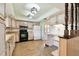 Bright eat-in kitchen with white cabinets, black appliances, and light wood-look flooring at 2101 Sunset Point Rd # 201, Clearwater, FL 33765