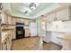 The vintage kitchen features wood look tile flooring and light green walls with matching vintage fixtures at 2101 Sunset Point Rd # 201, Clearwater, FL 33765