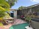 A quaint backyard with a hot tub, red grill, and table with chairs under a blue umbrella at 21045 Lazy Days Cir, Lutz, FL 33558