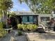 Home exterior with rock landscaping, a quaint porch, and mature plants, creating a charming and inviting atmosphere at 21045 Lazy Days Cir, Lutz, FL 33558