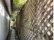 Shot of an exterior lattice fence bordering a narrow walkway, enhanced by vines and foliage for privacy and greenery at 21045 Lazy Days Cir, Lutz, FL 33558