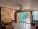 Comfortable living room features a sliding glass door to the backyard, tile flooring, and a ceiling fan at 21045 Lazy Days Cir, Lutz, FL 33558