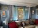 Cozy living room featuring a comfortable couch, decorative pillows, and natural light filtering through sheer curtains at 21045 Lazy Days Cir, Lutz, FL 33558