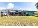 Spacious backyard showcasing a screened pool enclosure and a well-manicured lawn at 22348 Olean Blvd, Port Charlotte, FL 33952
