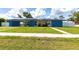 Bright blue single-story home featuring well-kept lawn, solar panels, and covered parking at 22348 Olean Blvd, Port Charlotte, FL 33952