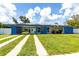 Charming blue house with solar panels, featuring a carport and well-maintained lawn at 22348 Olean Blvd, Port Charlotte, FL 33952