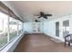 Relaxing sunroom featuring large windows, tile flooring, a ceiling fan, and double doors to the backyard at 22348 Olean Blvd, Port Charlotte, FL 33952