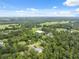 Expansive aerial view of a rural property featuring lush greenery and a large metal building, all under a partly cloudy sky at 2288 Rackley Rd, Brooksville, FL 34604