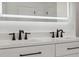 Modern bathroom vanity with double sinks, sleek hardware, a large mirror with lights, and white countertop at 2288 Rackley Rd, Brooksville, FL 34604