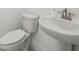 Modern bathroom featuring a white toilet and sink with brushed nickel fixtures for a sleek and clean look at 2288 Rackley Rd, Brooksville, FL 34604