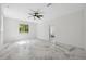 Bright, airy bedroom with white walls, ceiling fan, and marble-patterned floors; natural light fills the space from a large window at 2288 Rackley Rd, Brooksville, FL 34604