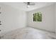 Bright bedroom featuring marble floors, a ceiling fan, and a window with views of lush greenery at 2288 Rackley Rd, Brooksville, FL 34604