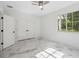 This airy bedroom features marble floors, a ceiling fan, and closet space, enhanced by natural light from the window at 2288 Rackley Rd, Brooksville, FL 34604