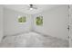 Bright bedroom with a ceiling fan, two windows, and stylish marble flooring, offers a serene living space at 2288 Rackley Rd, Brooksville, FL 34604
